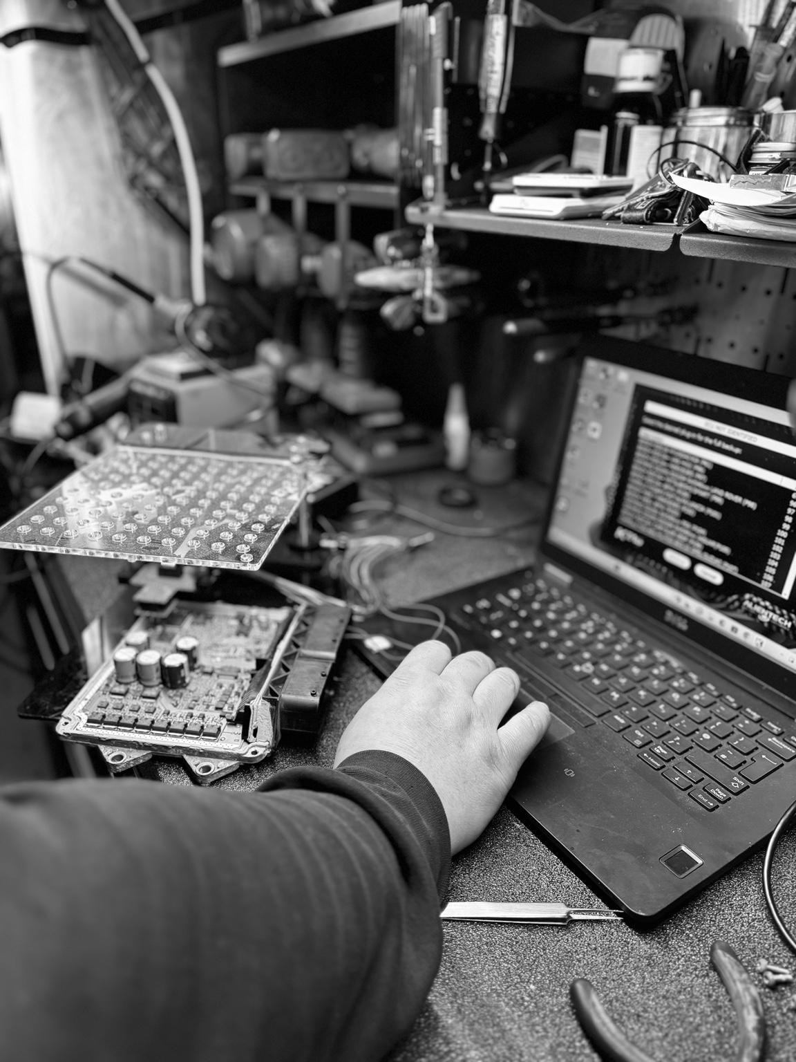 Hands-on work with an open engine control unit and a laptop on the workshop bench